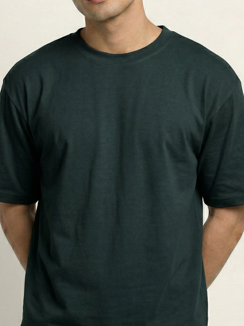 Person wearing a plain green t-shirt against a neutral background