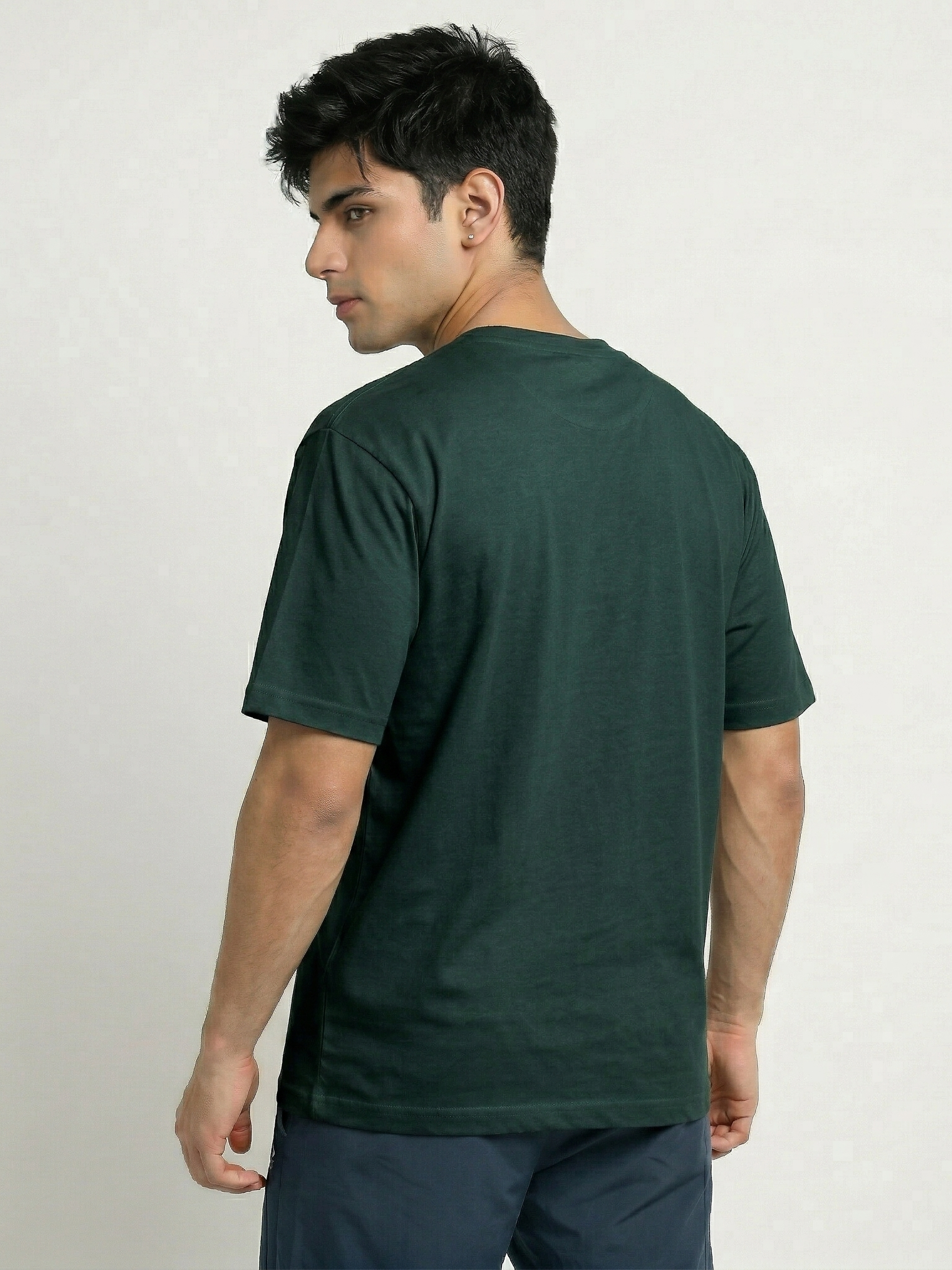 Man wearing a green t-shirt on a plain background