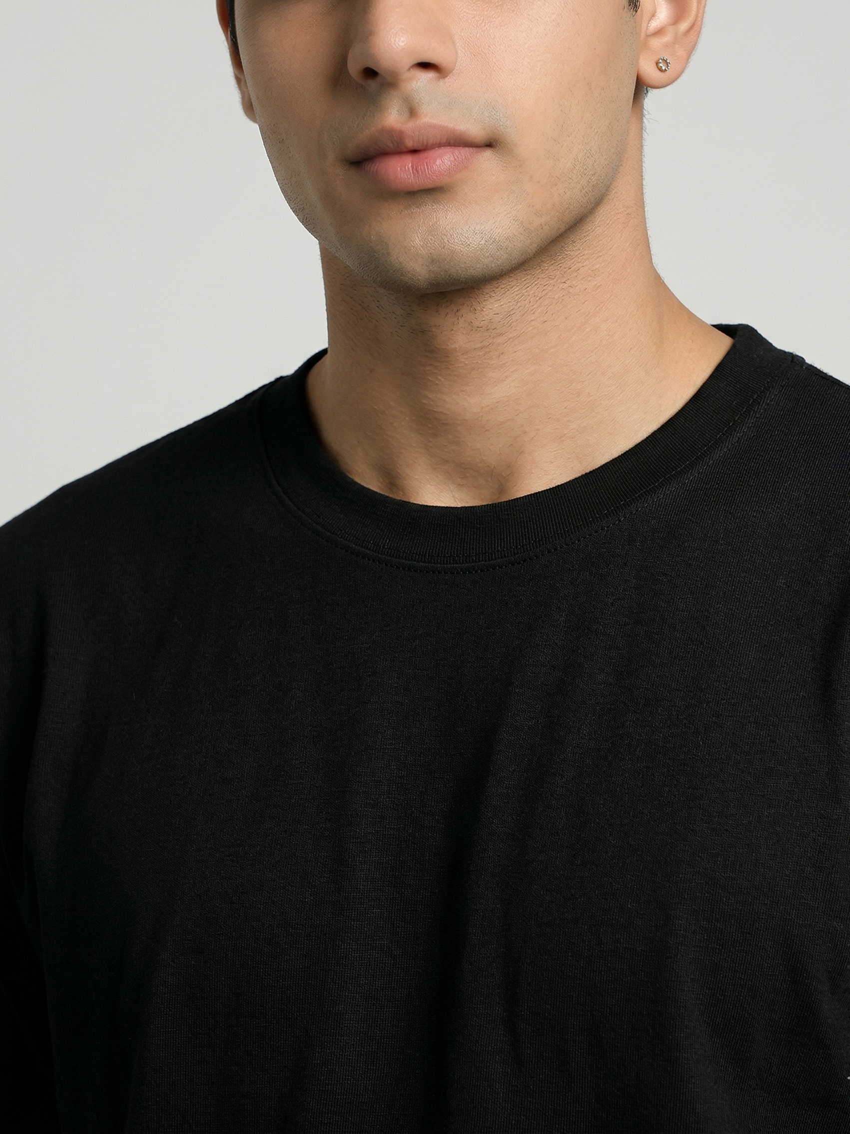 Man wearing a black t-shirt against a plain background