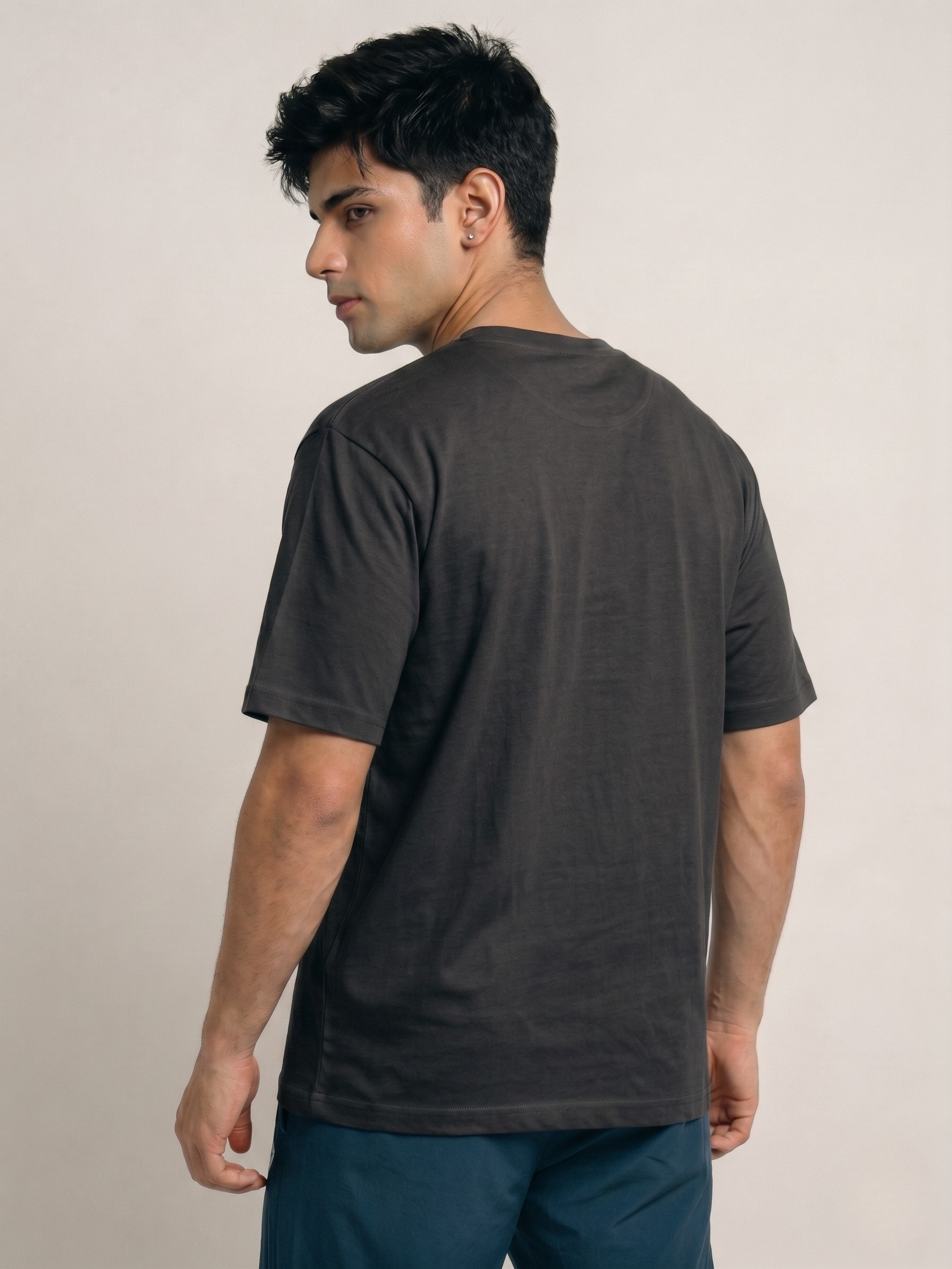 Man wearing a dark gray t-shirt against a plain background
