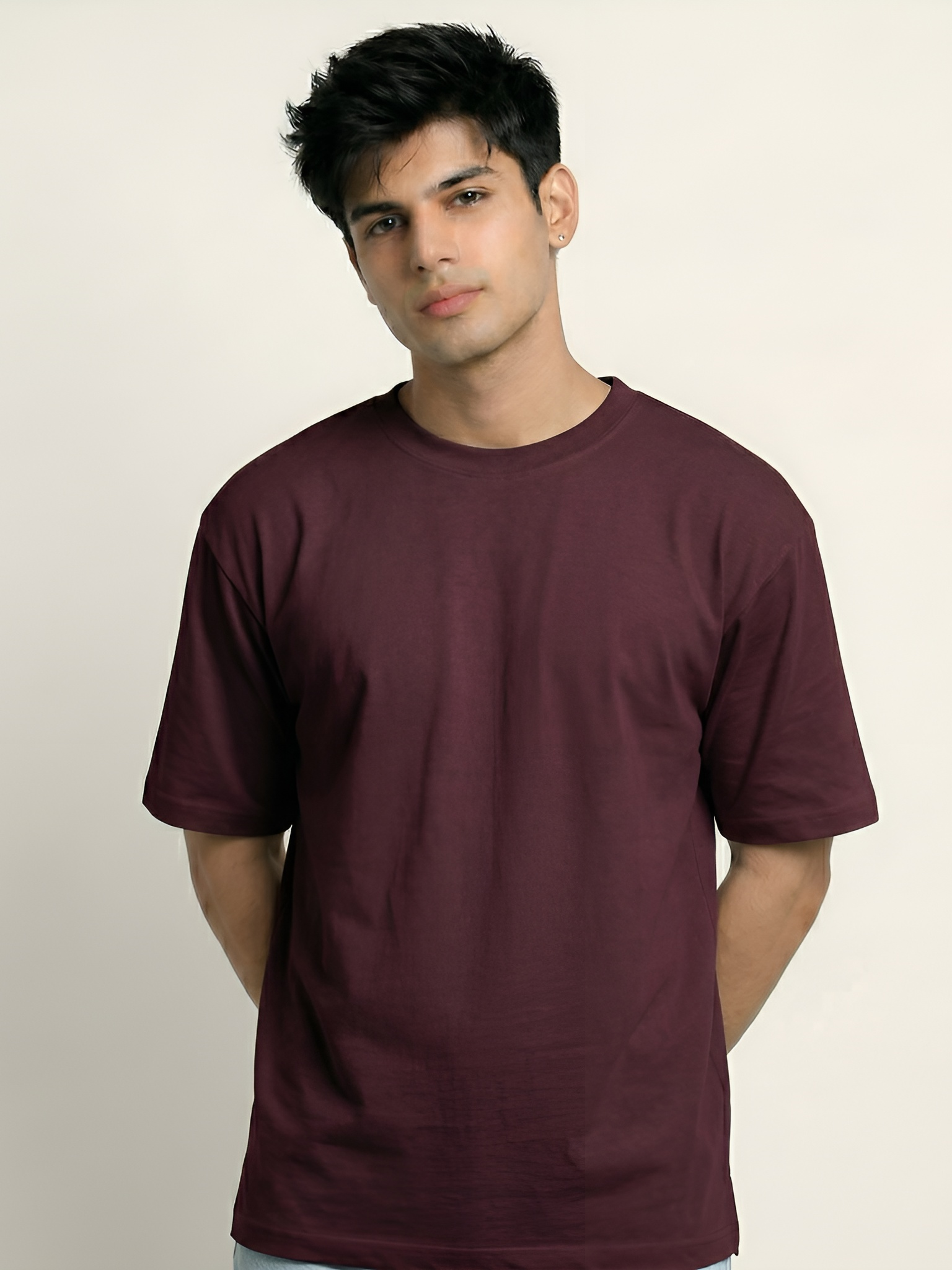 Man wearing a maroon t-shirt against a plain background