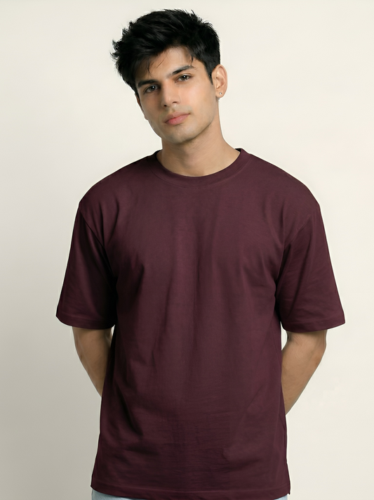 Man wearing a maroon t-shirt against a plain background