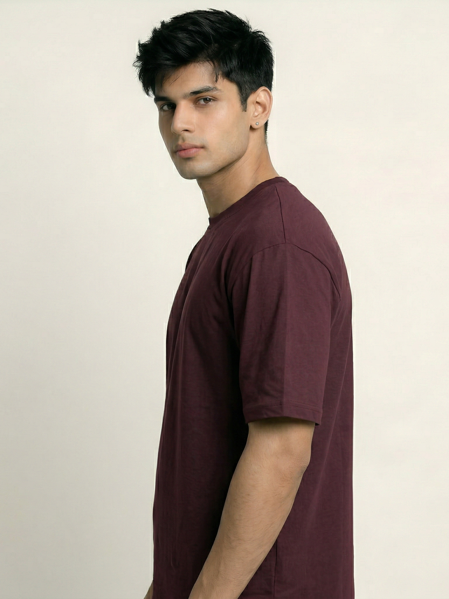 Man wearing a maroon t-shirt against a plain background