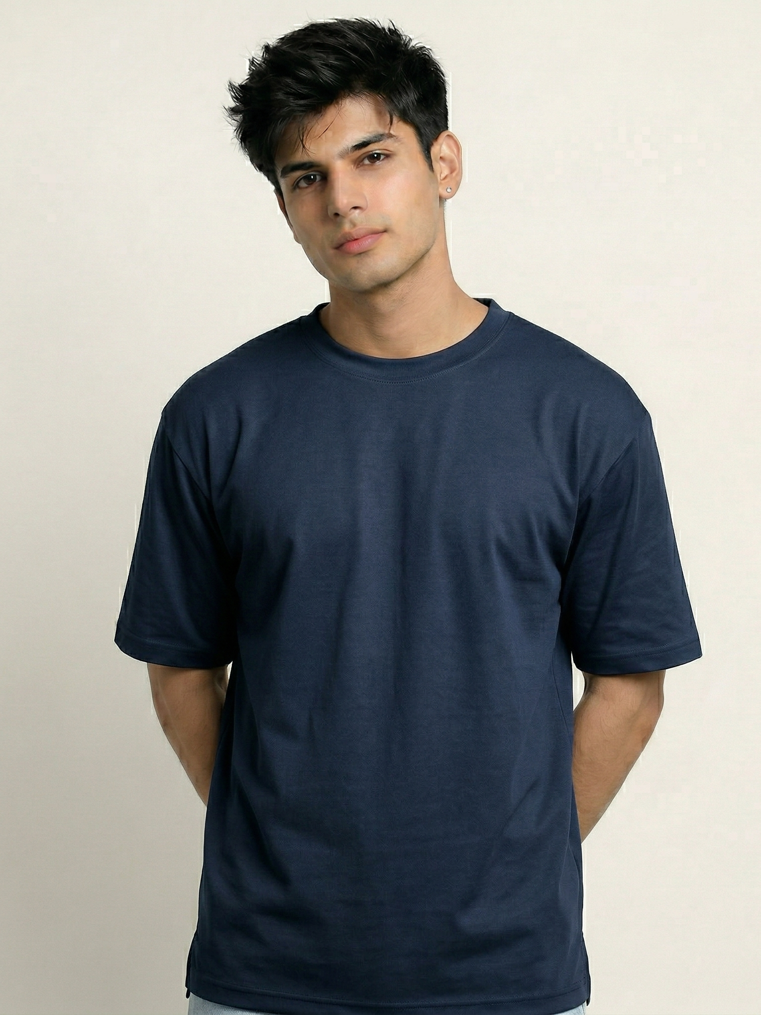 Man wearing a navy blue t-shirt against a beige background