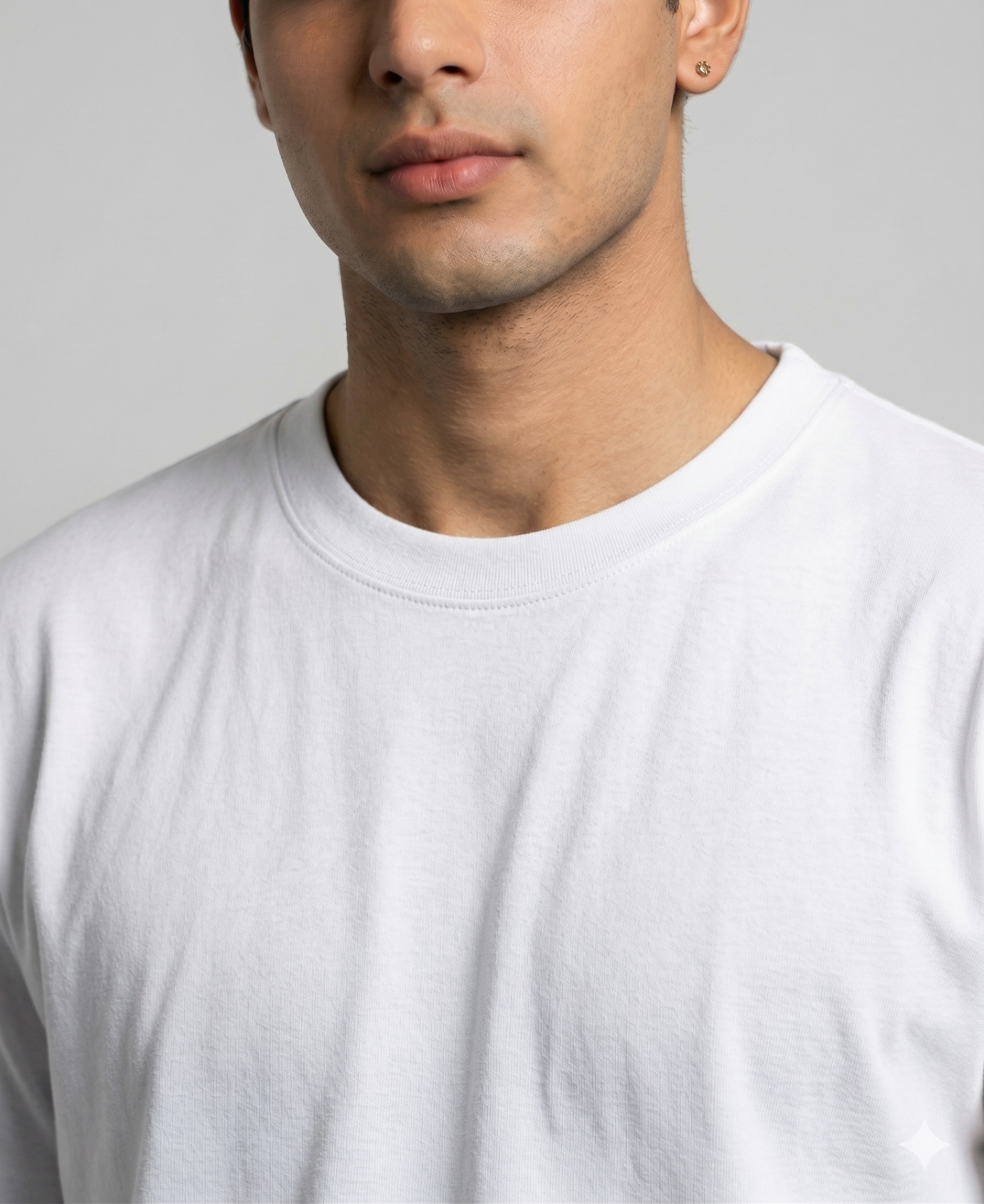 Man wearing a plain white t-shirt against a gray background